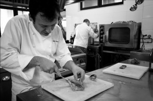 Chef Nacho Manzano cutting fish in his kitchen