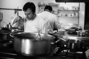 Chef Nacho Manzano in the kitchen, tasting stock