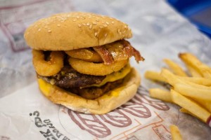 A bacon and onion ring cheese burger
